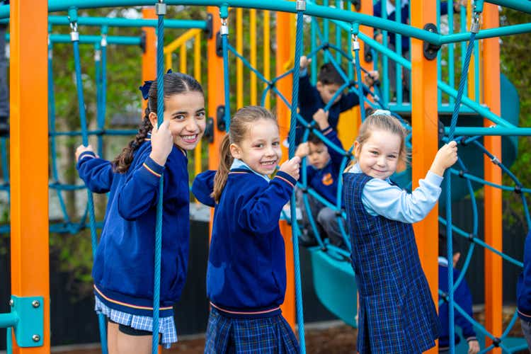Three girls playing on playground equipment